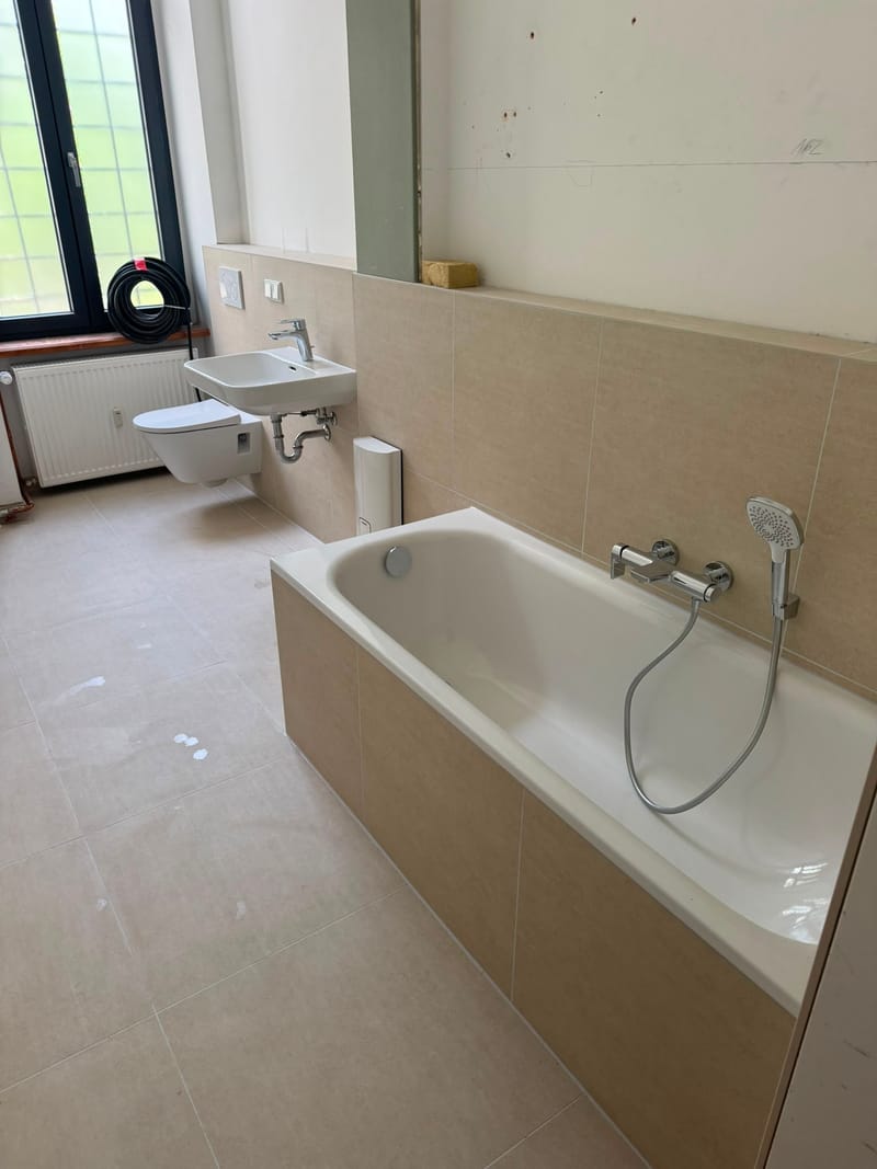 Fertig saniertes Bad mit Badewanne und Hänge-WC aus einem G.E.N.F.-Projekt