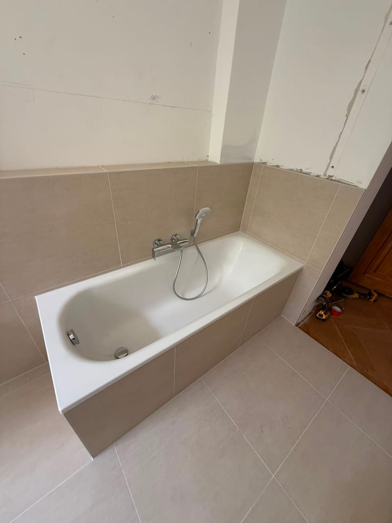 Eingeflieste Badewanne mit verchromter Armatur und Handbrause